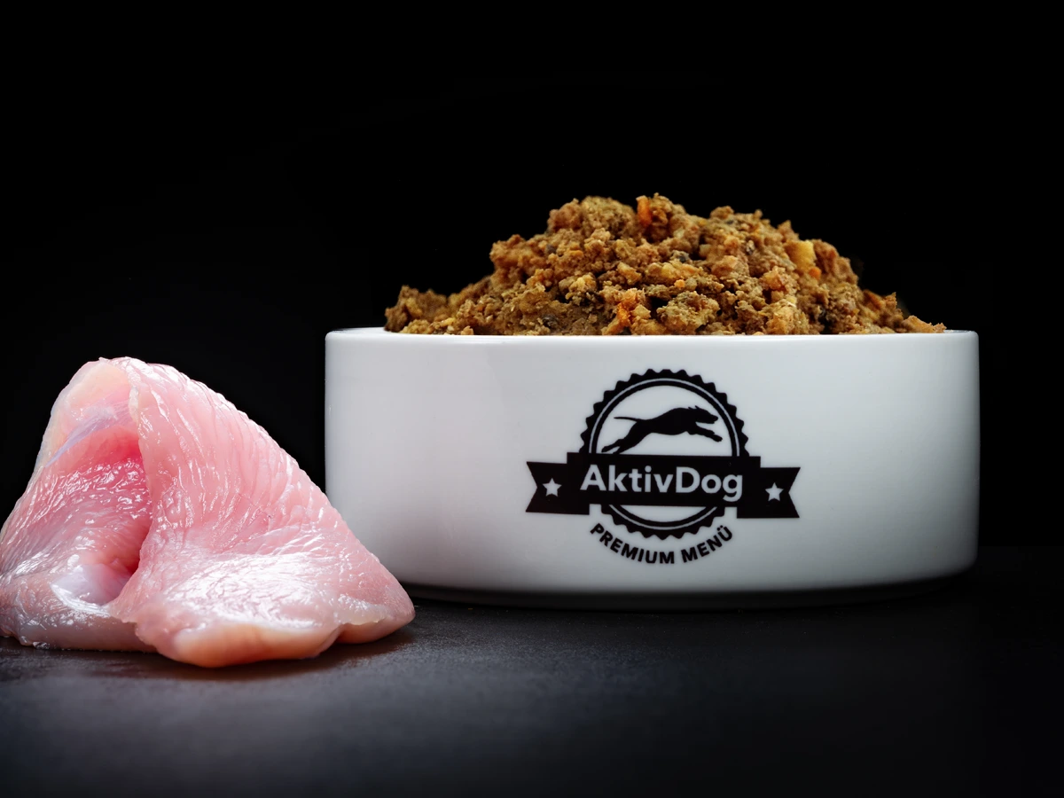 Großaufnahme von AktivDog Hundefutter Truthahn mit links daneben liegendem rohen Schweizer Truthahnfleisch